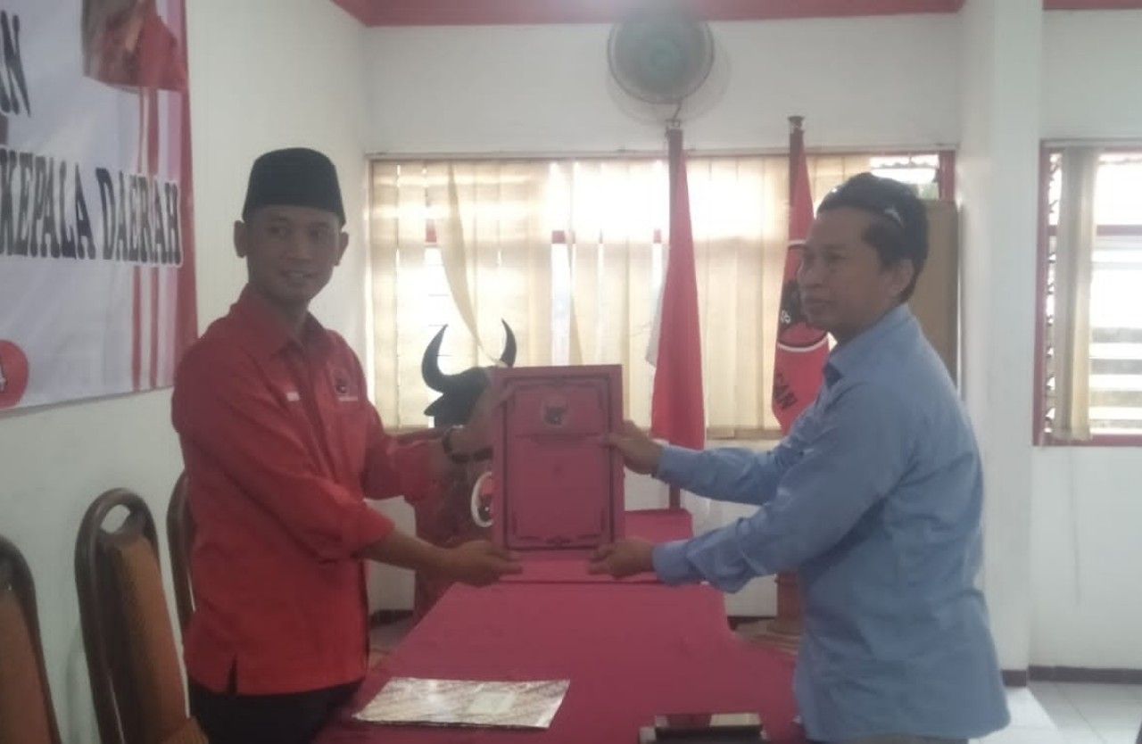 Isma Hakim Rahmat alias Mas Hakim, menyerahkan formulir pendaftaran.