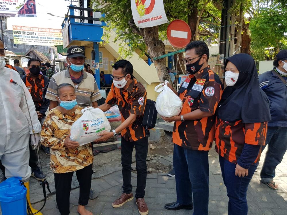 Ketua Gugus Tugas Relawan kemanusiaan Task Force Covid-19,Pemuda Pancasila Kota Surabaya 
 Samsurin menyerahkan sembako kepada warga